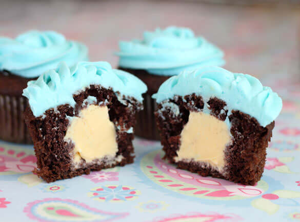 four cupcakes with blue icing on top