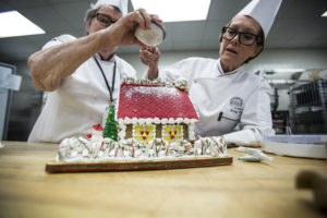 Two chefs decorating a cake